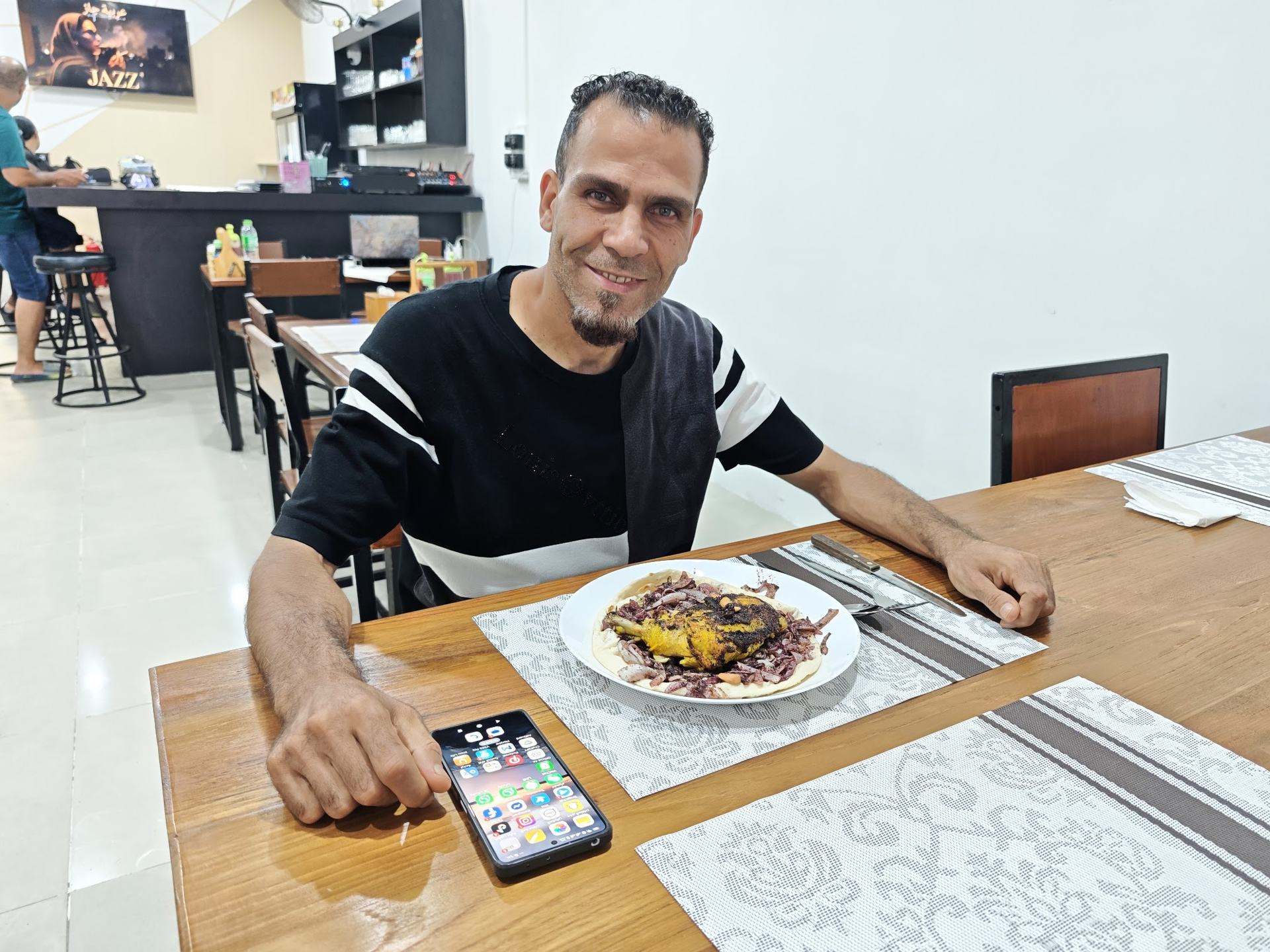 A happy guest enjoying traditional Palestinian musakhan at Jerusalem Restaurant Patong